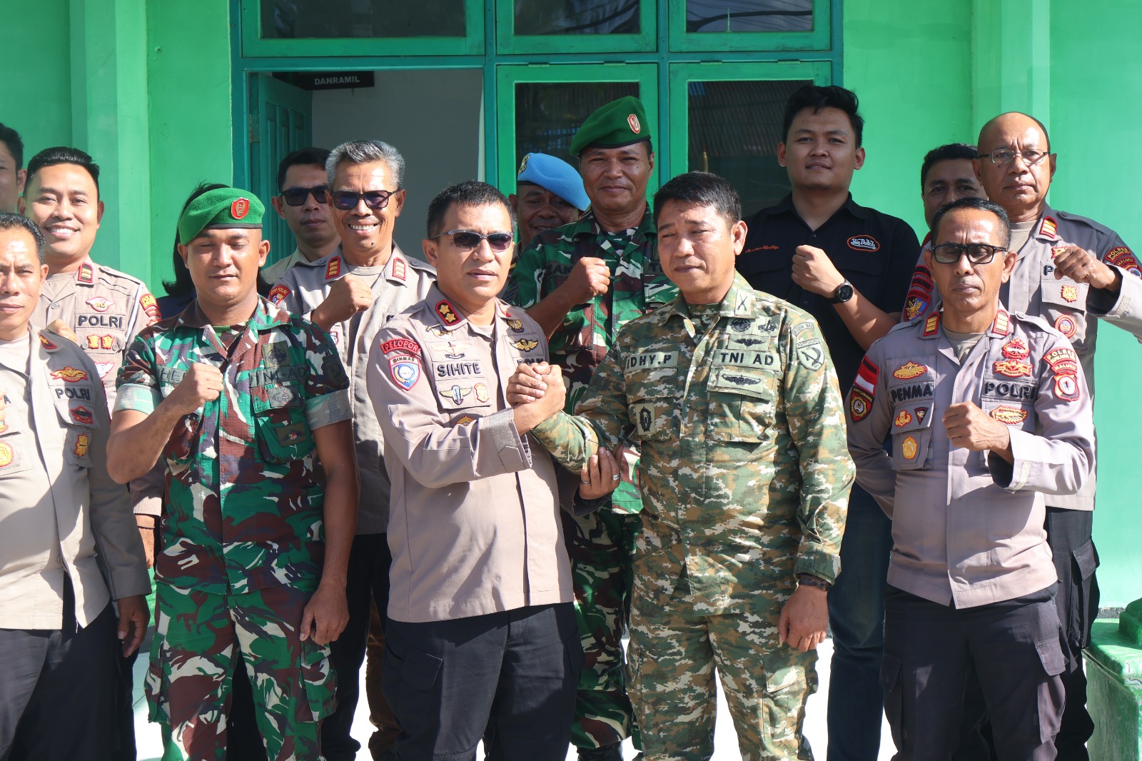 Kapolres Kepulauan Aru berfoto bersama jajaran TNI dan Kejaksaan di depan gedung Koramil Dobo sebagai simbol sinergitas antar‑instansi.