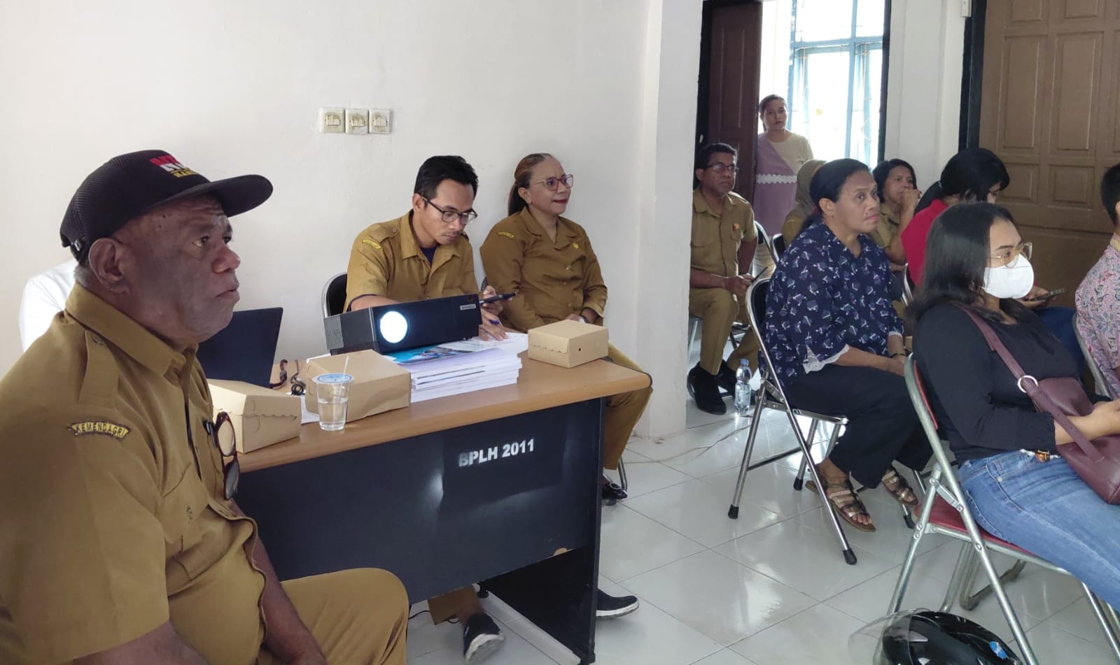 Pejabat DLH Kepulauan Aru memaparkan sistem pengawasan berbasis kode QR kepada peserta sosialisasi di ruang pertemuan.