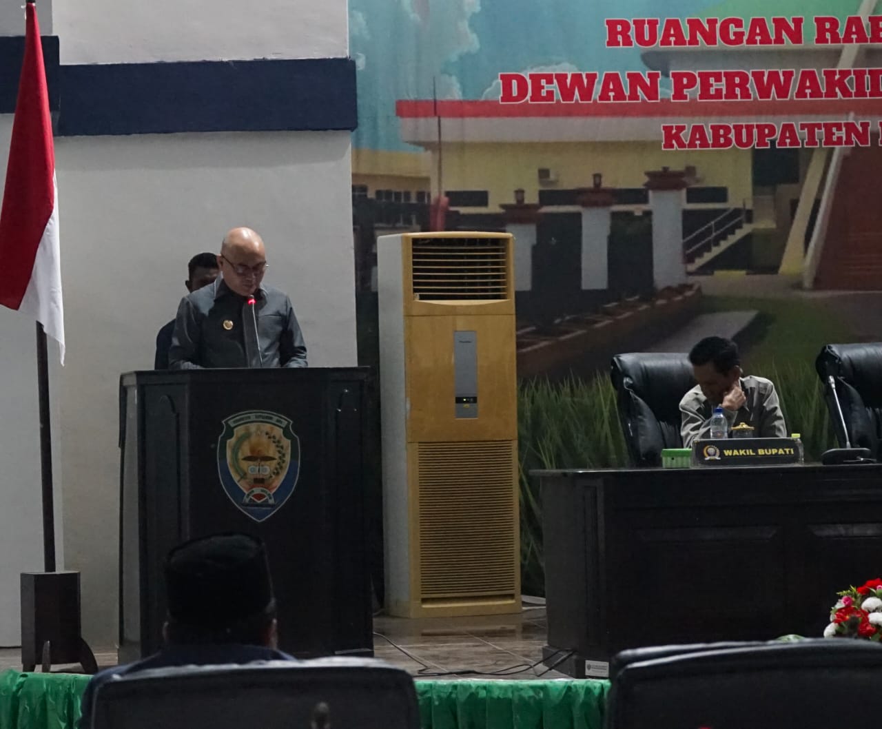 Perwakilan Pemerintah Kabupaten Kepulauan Aru berdiri di podium menyampaikan pidato Nota Pengantar Ranperda APBD-P Tahun 2026 di hadapan pimpinan DPRD.