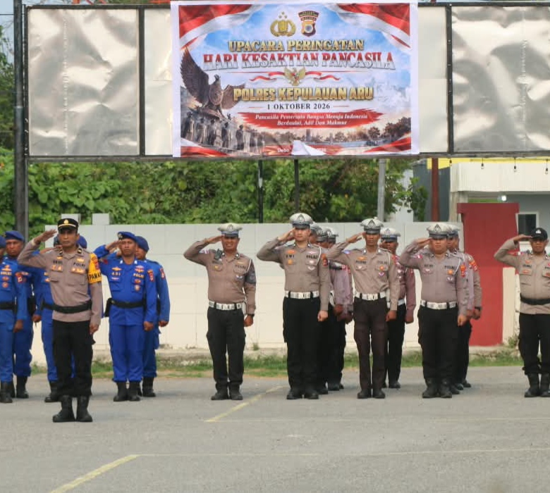 Barisan personel Polres Kepulauan Aru memberikan sikap hormat di depan spanduk Upacara Peringatan Hari Kesaktian Pancasila 2026