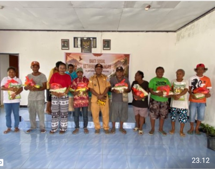 Mananwir Er Sroyer bersama warga Kampung Inggiri memegang bantuan paket sembako dalam bakti sosial ketahanan pangan Hari Tani Nasional 2026