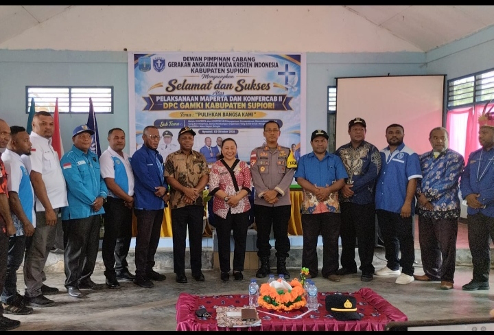 Foto bersama panitia, pengurus DPC GAMKI Supiori, jajaran kepolisian, dan tamu undangan di depan baliho Maperta dan Konfercab II